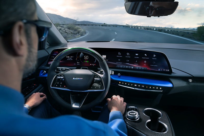 Front View of the 2026 OPTIQ-V Driving Through the Dusk Utilizing its Headlights | Bayway Cadillac Southwest in Houston TX