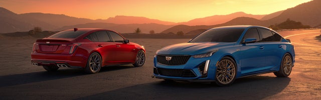 A Red and a Blue Cadillac CTS-V shown in a sunset scene